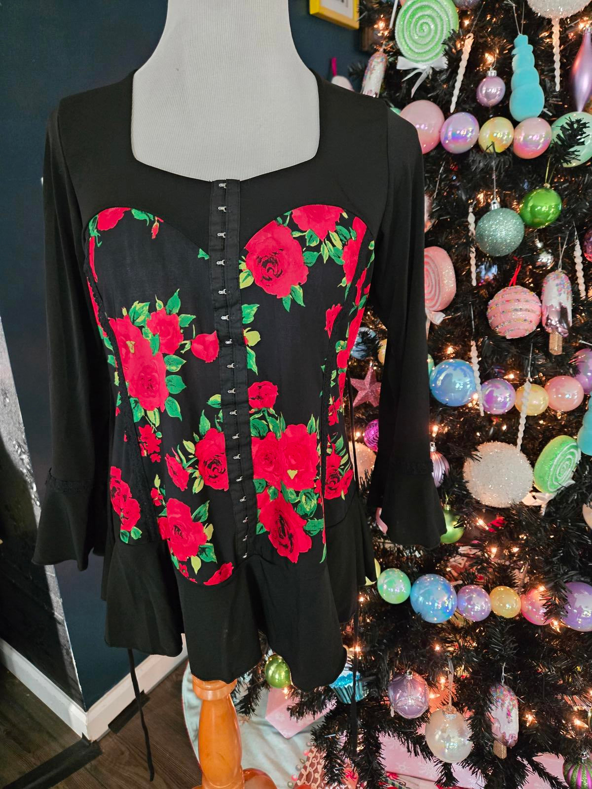 Rose corset style tunic top with bell sleeves and ruffle hem